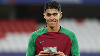 Mid-30s anonymous NEC midfielder, athletic build, waist-up, wearing a plain dark-red and green training top with smooth...