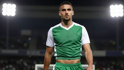 A photorealistic image of an anonymous Nijmegen player, aged 25-30, wearing a green and white jersey, with a white collar...