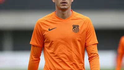 A mid-30s anonymous male forward in a solid orange N.E.C